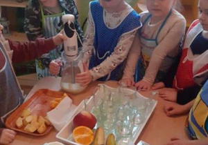Dzieci blendują jogurt z owocami.